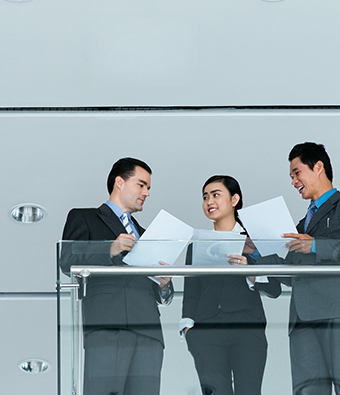 three people meeting in glass conference room