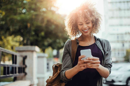 image of woman on street looking at phone