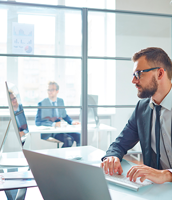 man working at sunny desk in office